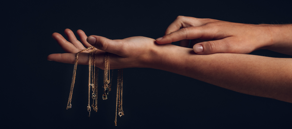 hand with 14k gold necklaces
