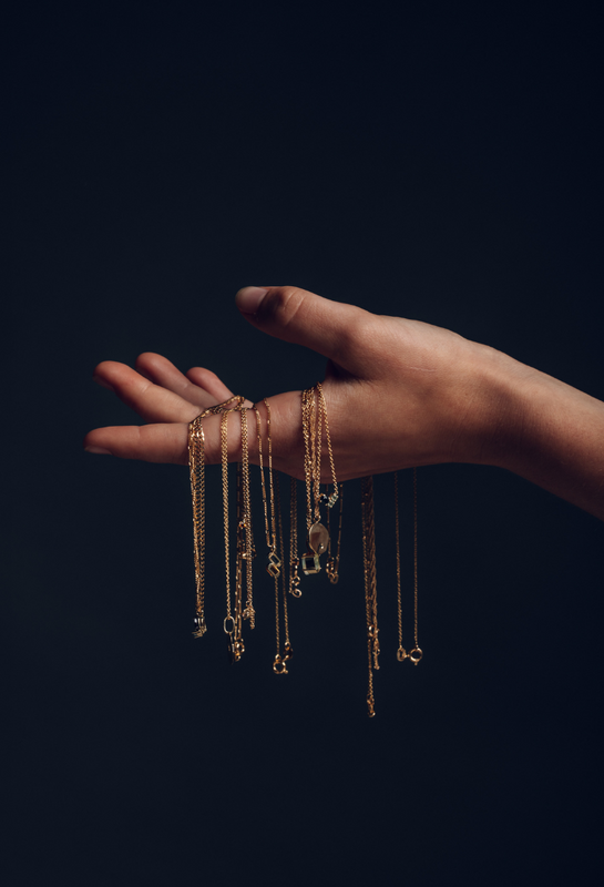 elegant hand with 14k gold necklaces